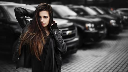 黑色汽车的背景上的黑发女孩