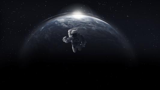 在开放空间的宇航员以地球为背景