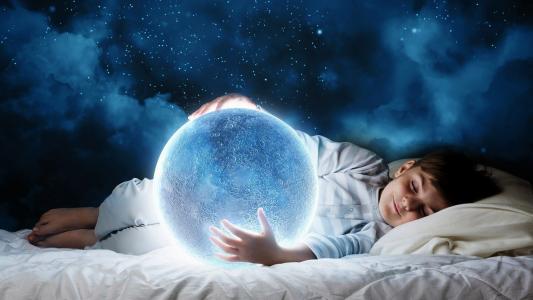 一个梦中的小男孩手中拿着一个神奇的蓝色月亮