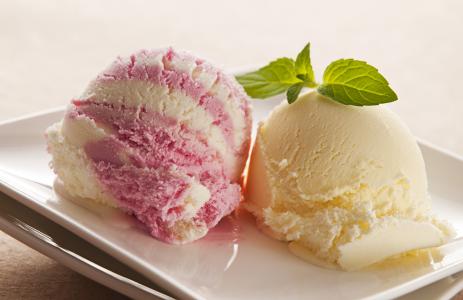 两个水果冰淇淋球用薄荷叶在白板上