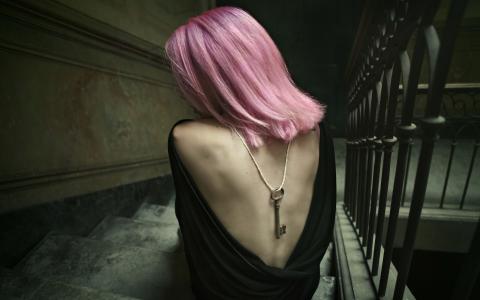 坐在楼梯上的粉红色头发的女孩