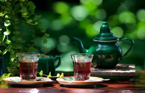 两杯茶和一个绿色的水壶在桌子上