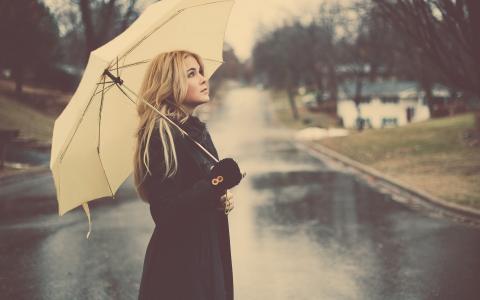 在雨中的白色雨伞的金发女郎