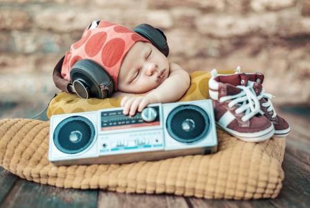 睡着的婴儿在耳机和玩具录音机