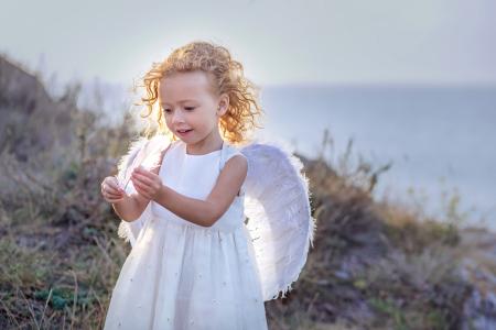 漂亮的小女孩，穿着白色与天使的翅膀