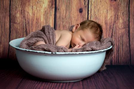 一个新生的婴儿睡在一个白色的碗里