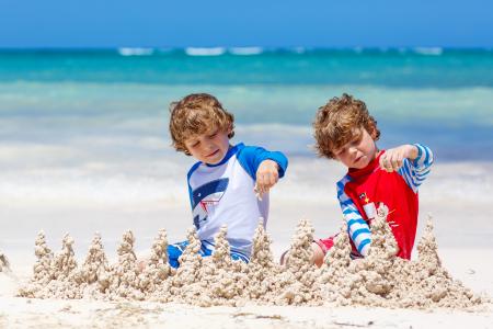 两个小男孩在沙滩上玩沙子