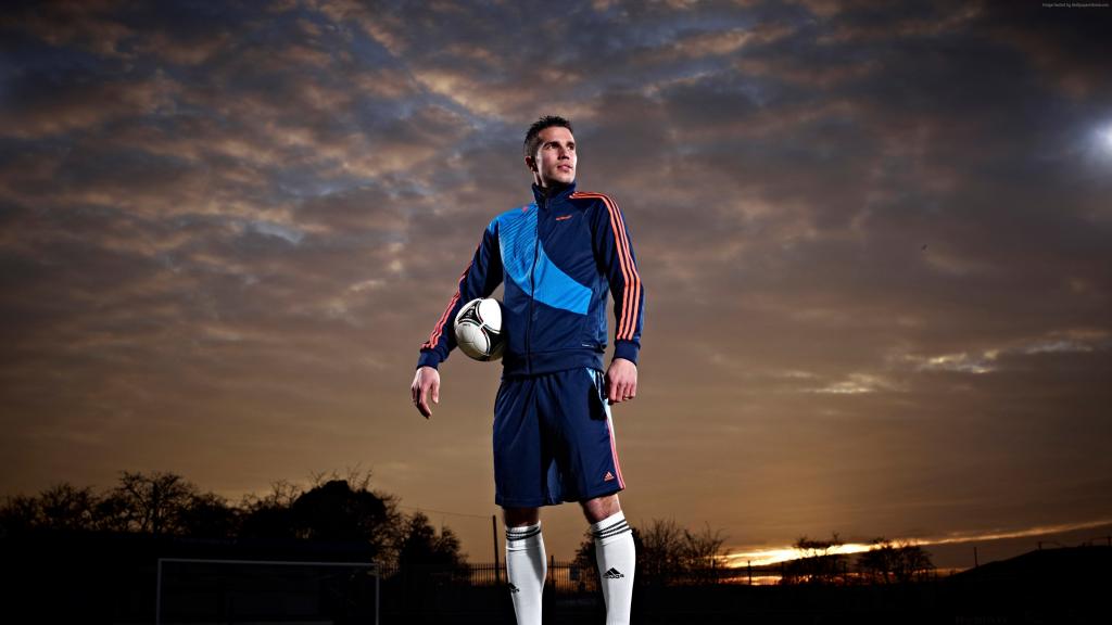 与球的足球运动员罗宾·范·佩西在天空背景