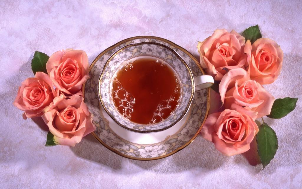 一杯美丽的红茶与粉红玫瑰的桌子上