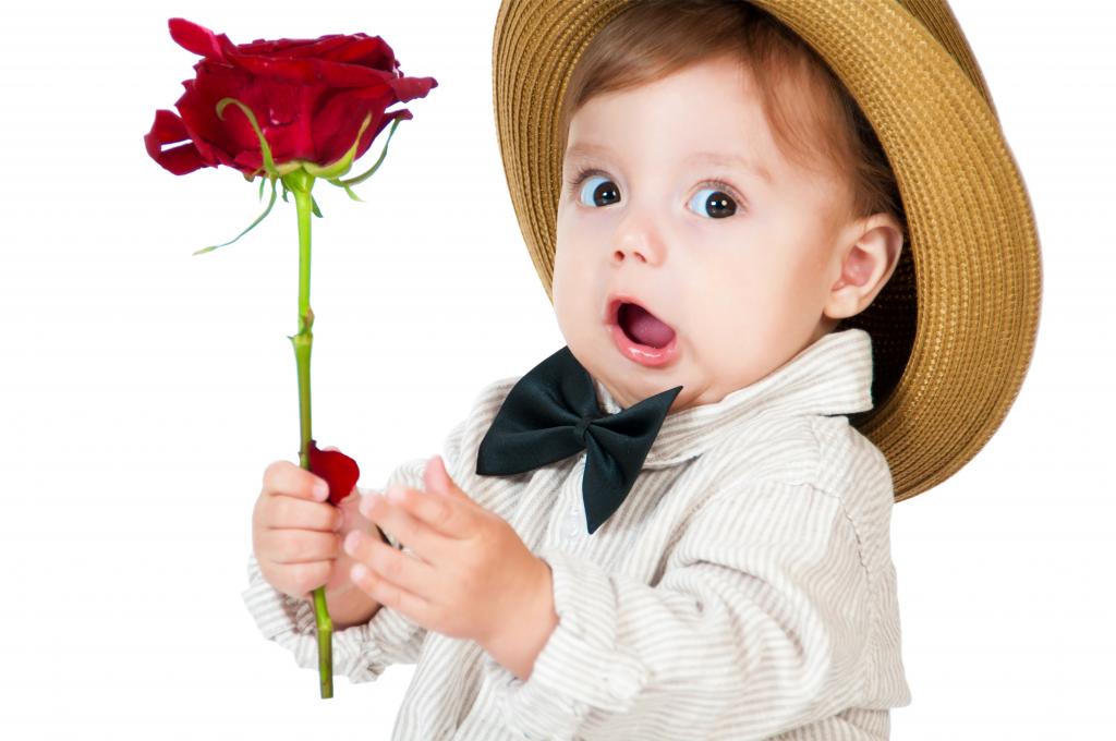 有趣的小男孩，在他手中的一朵红玫瑰的帽子