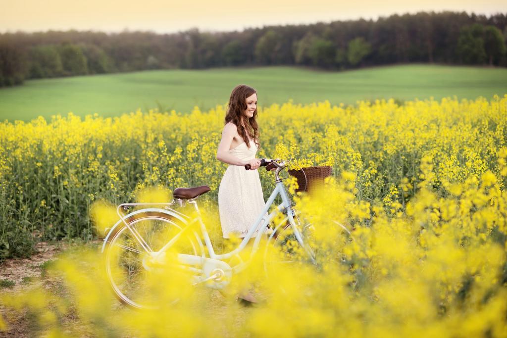 一辆自行车在黄色的花之间的女孩
