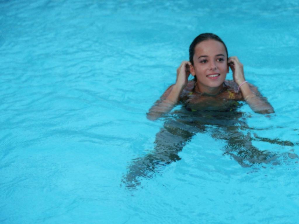 美丽的姑娘在游泳池里的阿里泽