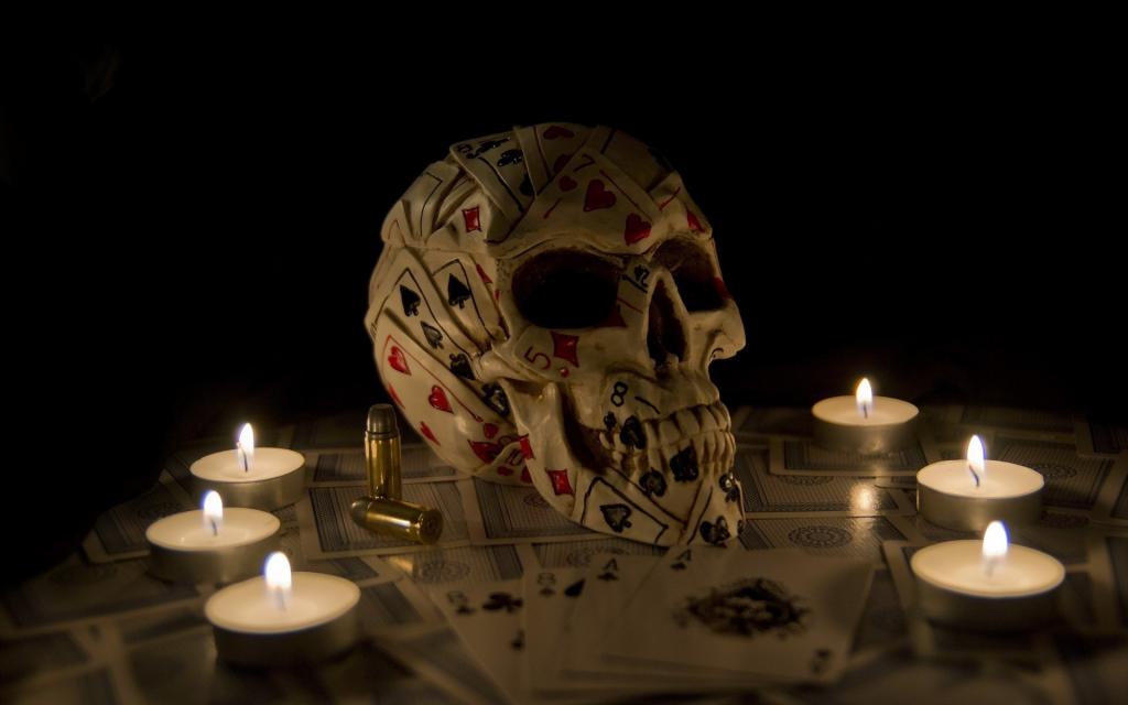 在蜡烛之间的纸牌的头骨