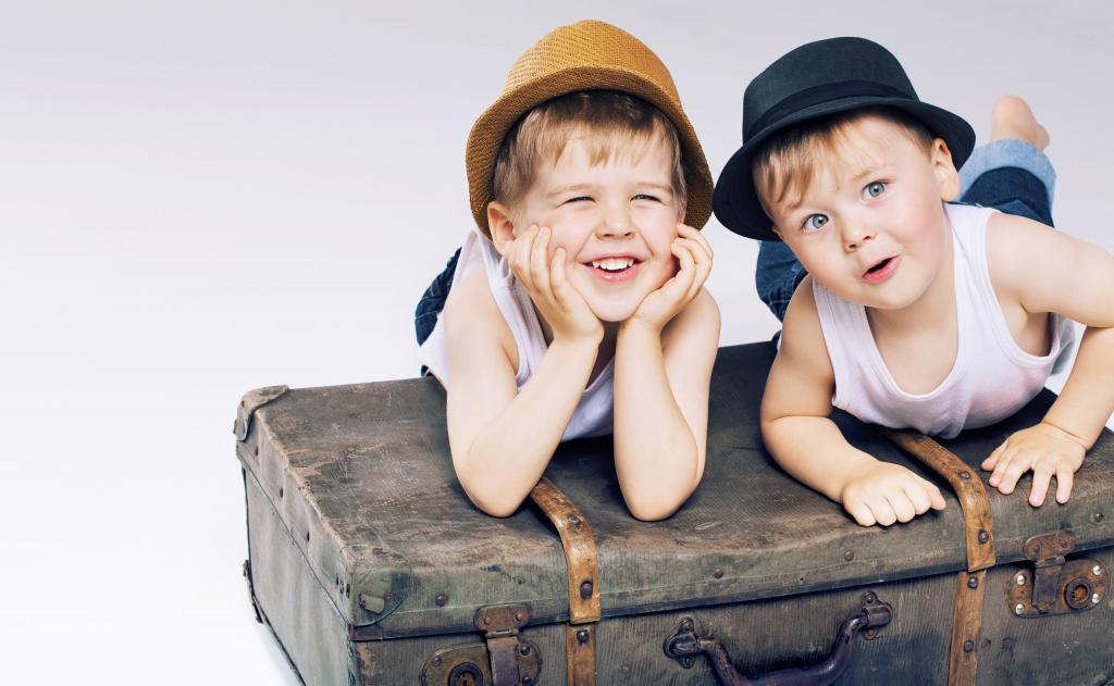 两个小男孩躺在一个旧手提箱上