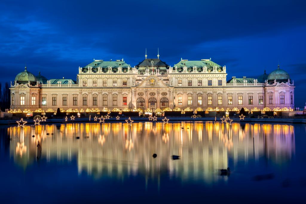 在晚上的宫殿复杂丽城反映在池塘，维也纳。