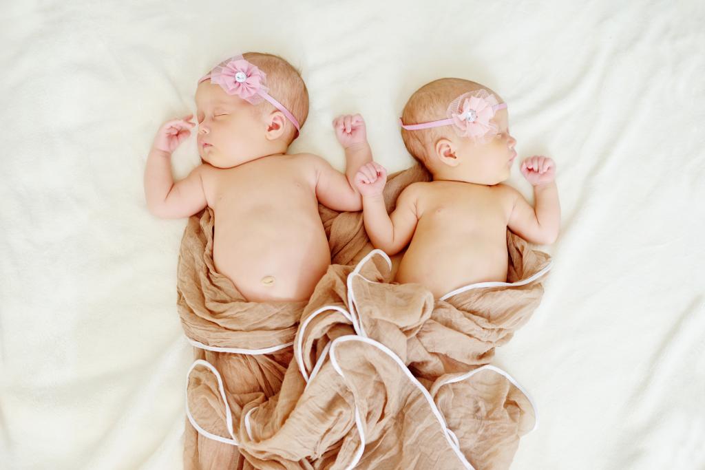 两个睡着的婴儿头上有粉红色的花朵