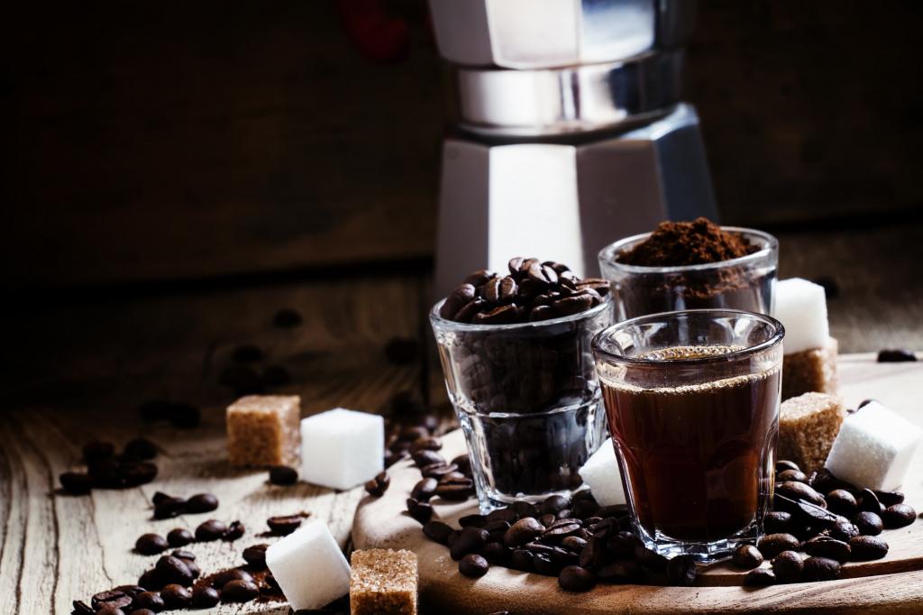 与咖啡，咖啡豆和研磨咖啡与糖立方的桌子上的眼镜