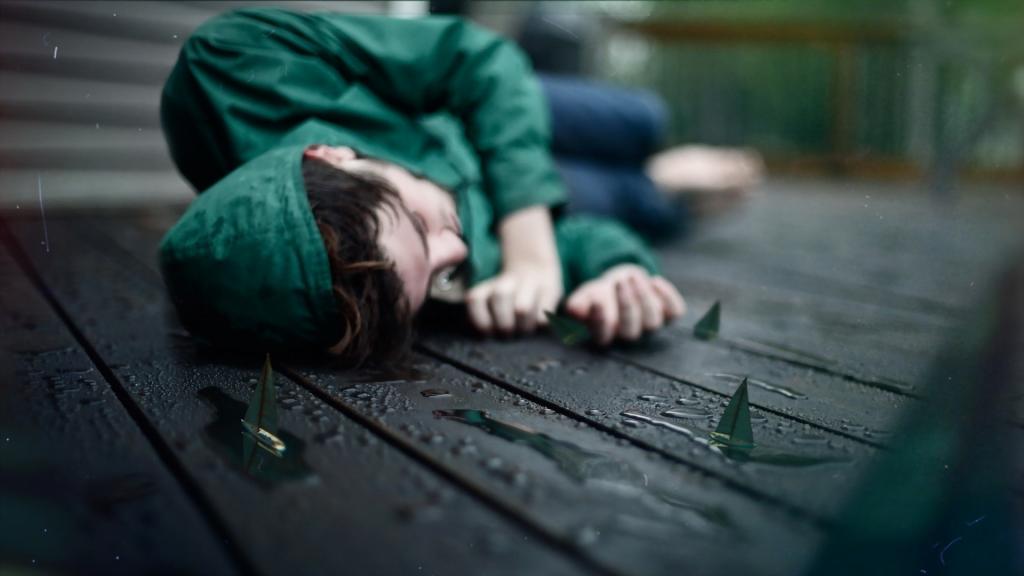 一个绿色的女孩躺在湿板上