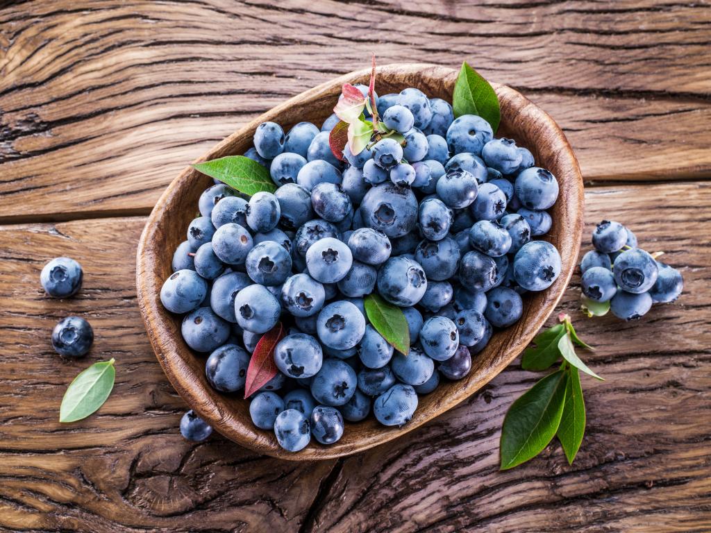 新鲜的蓝莓浆果在一张木桌上的盘子