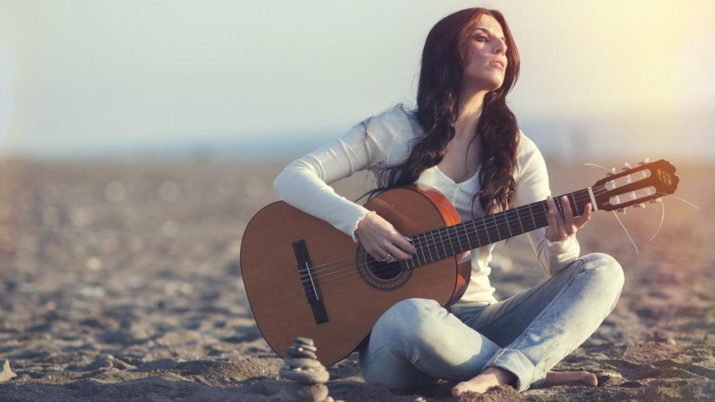 希腊女孩坐在沙滩上的一把吉他