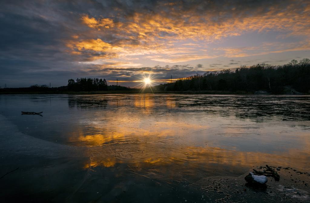 冰冻的湖面上的寒冷的太阳的黎明