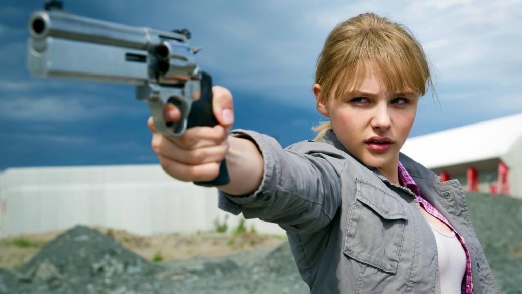 模型的女孩拿着枪在她的手中
