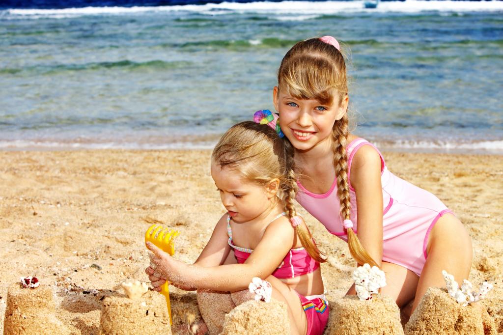 两个小女孩在沙滩上走在沙滩上