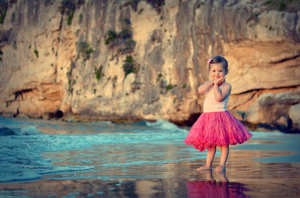 美丽的粉红色裙子，在海滩上的小女孩