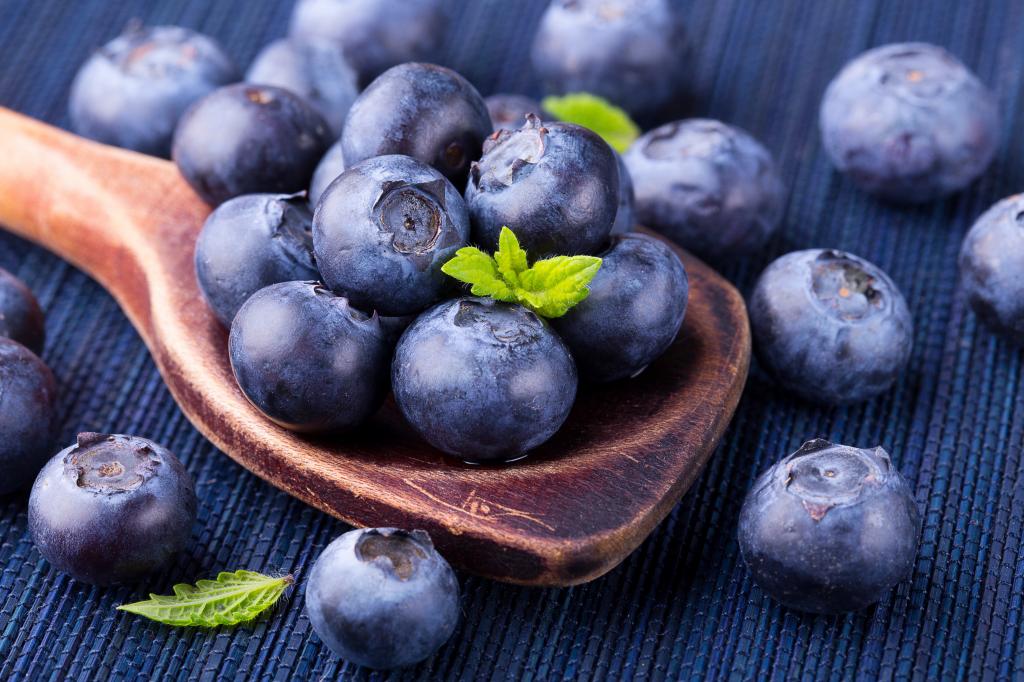 成熟的蓝莓浆果木勺特写