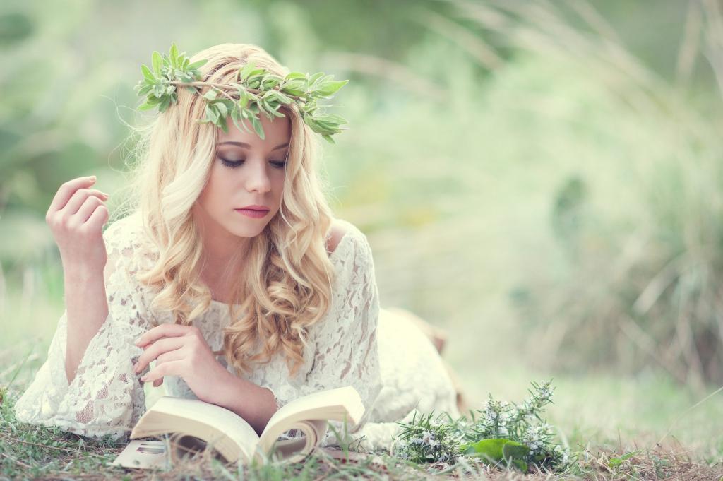 读一本书的一个绿色花圈的金发碧眼的女人
