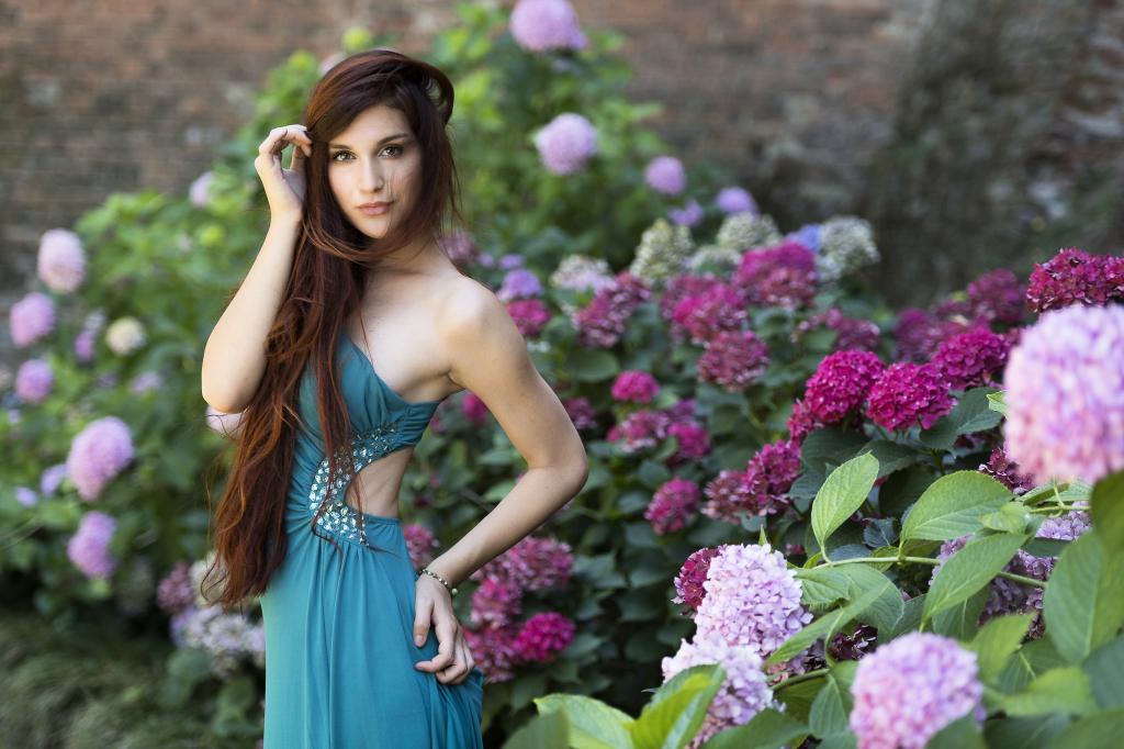 美丽的女孩模型旁边花绣球花的绿色的裙子