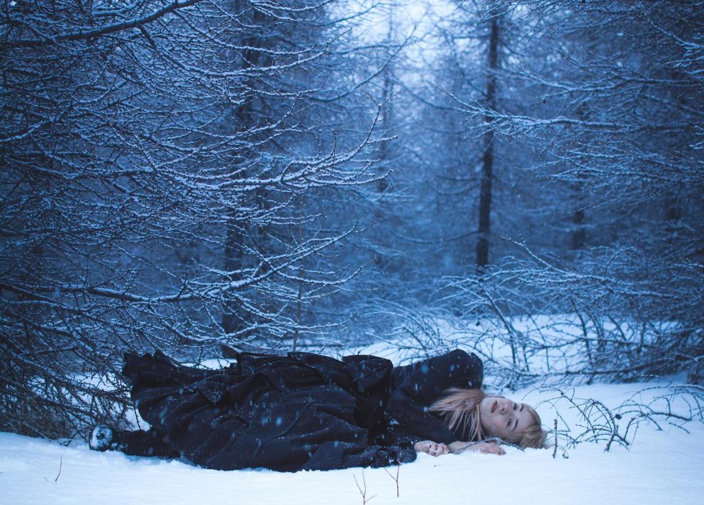 金发躺在森林里的雪地上