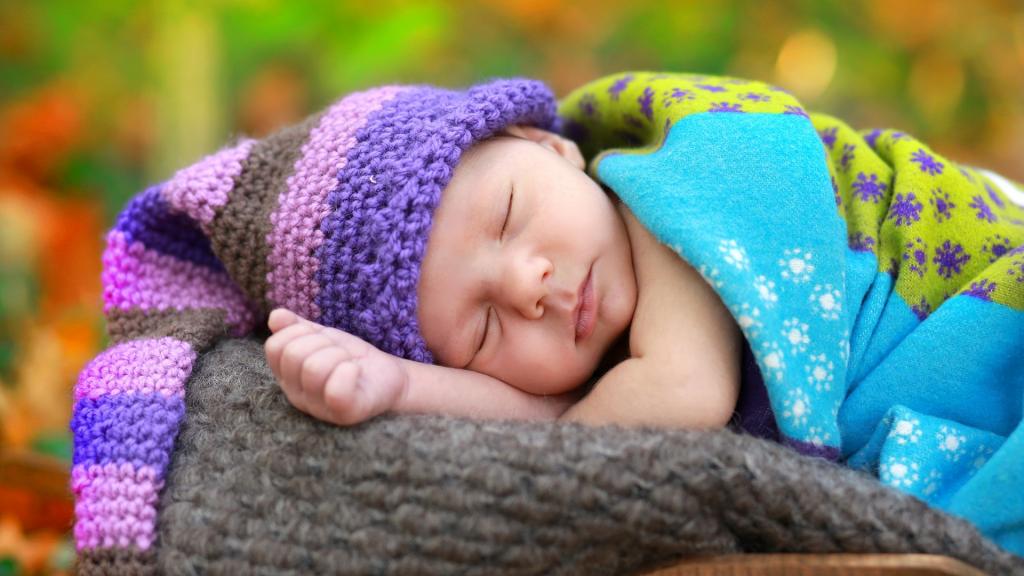 一个小睡觉的婴儿在一个针织的帽子
