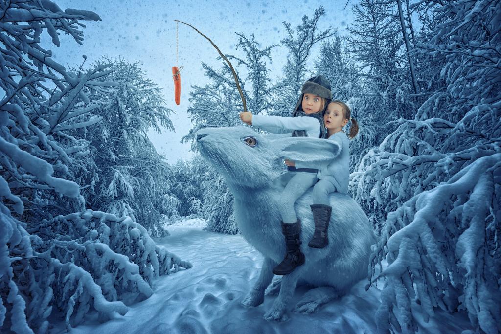 两个有趣的女孩正坐在冬季森林里的大魔法兔