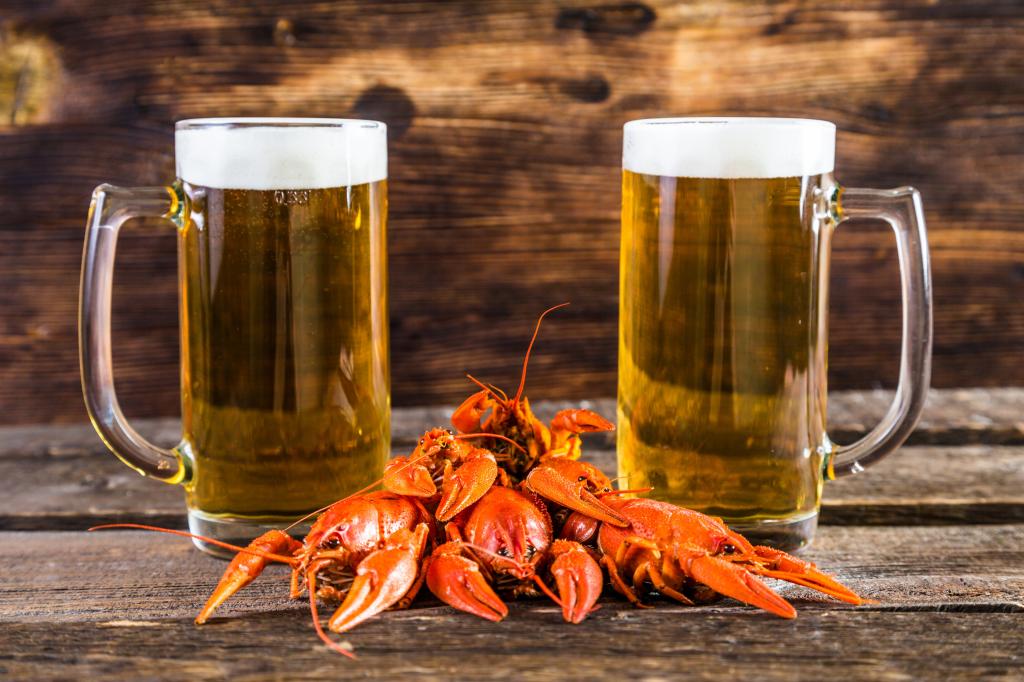 两杯啤酒与红色的小龙虾在桌子上
