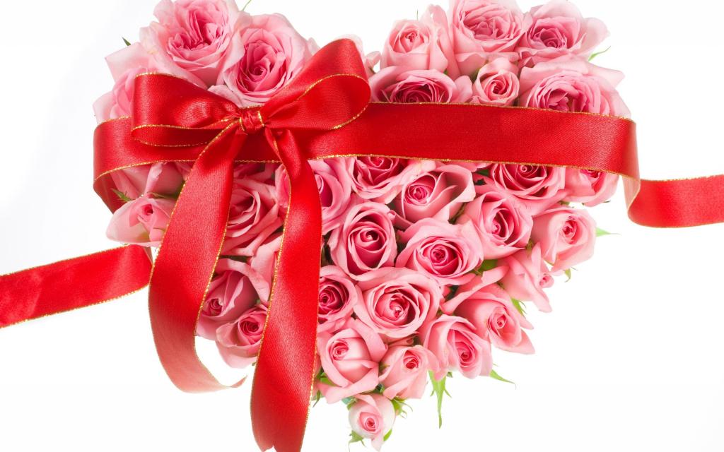 粉红玫瑰的心脏与红丝带在白色背景上