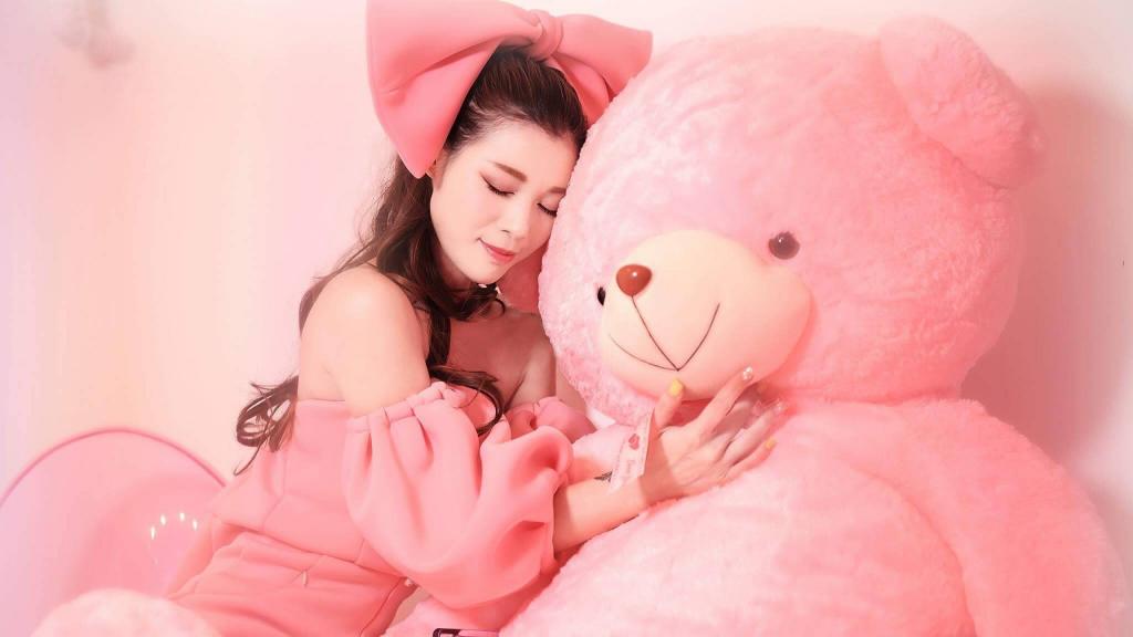 美丽的亚洲女孩与一个大的粉红色的熊