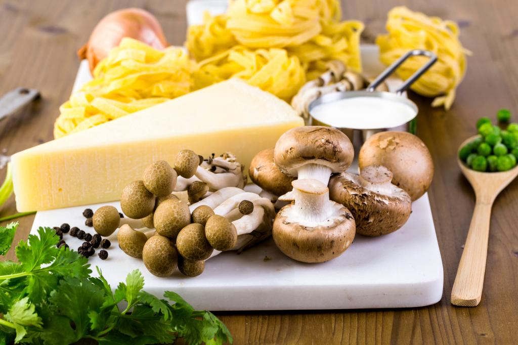在与砧板，奶酪，意大利面和绿色的蘑菇