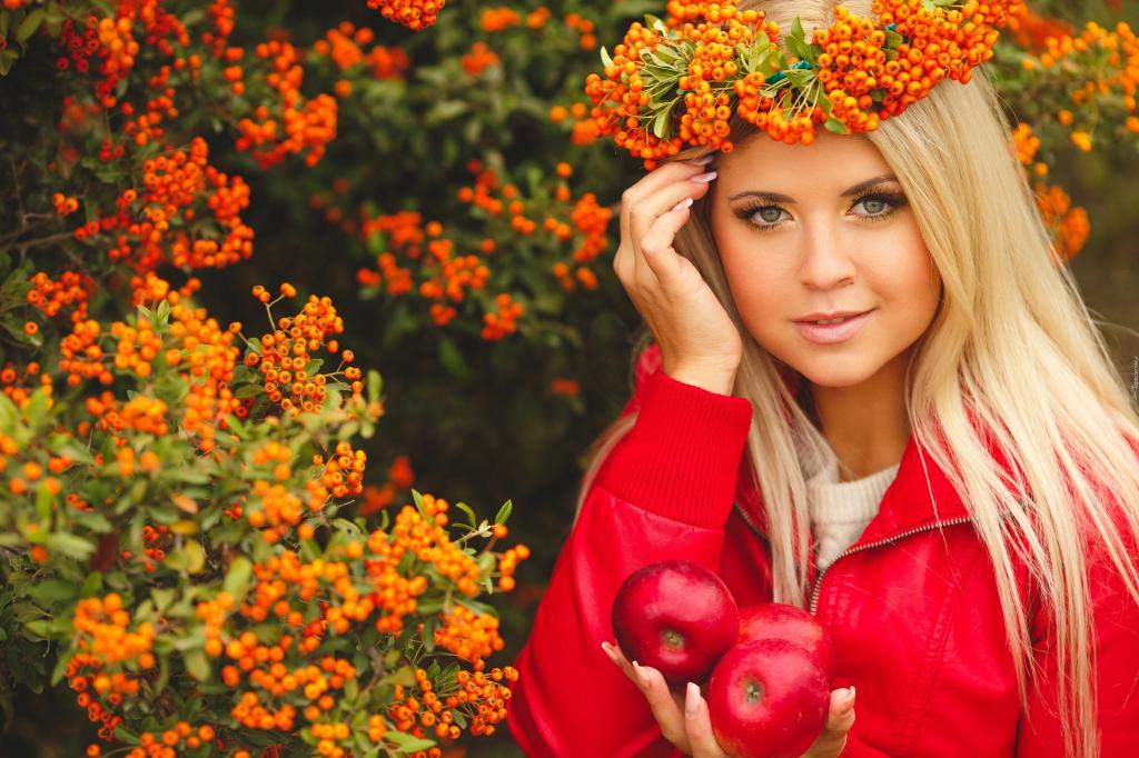 美丽的女孩，与她的头上的山灰花环和在她手中的红苹果