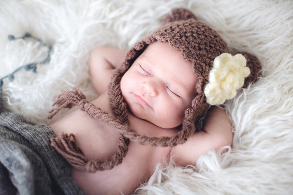 睡在一个针织的棕色帽子的婴儿