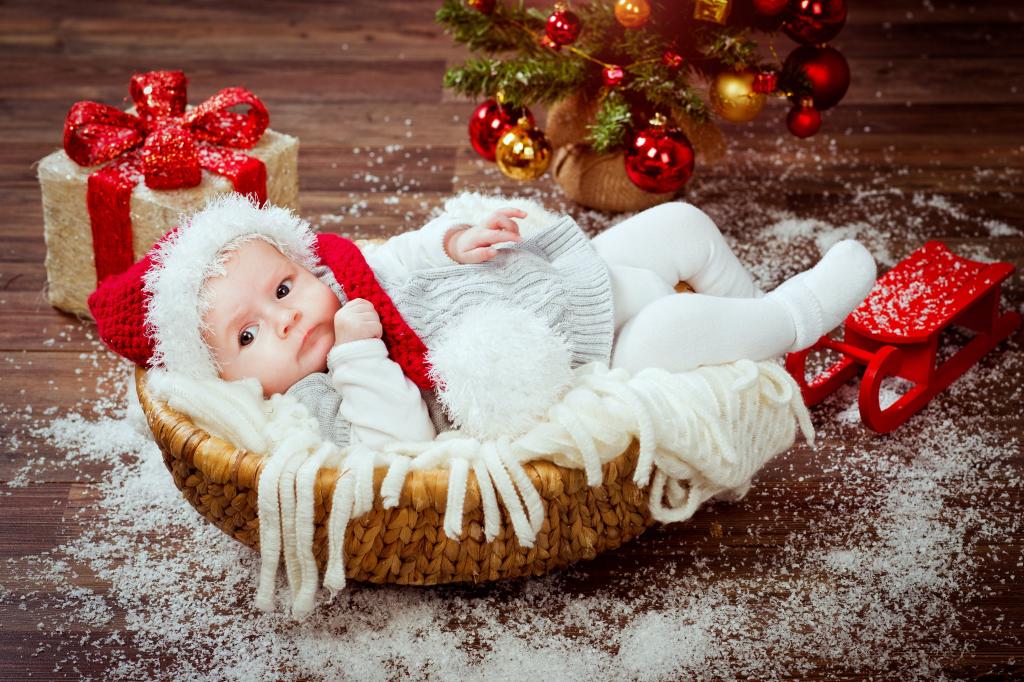 在一个新的一年的西装，在与礼物的圣诞树下的篮子里的婴儿