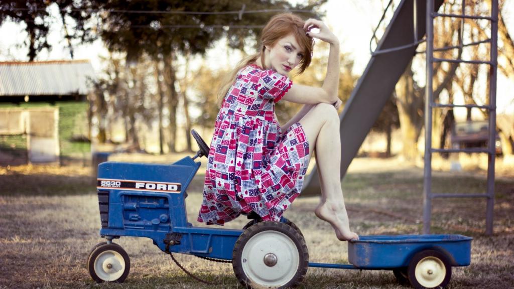 一个女孩坐在孩子的拖拉机上
