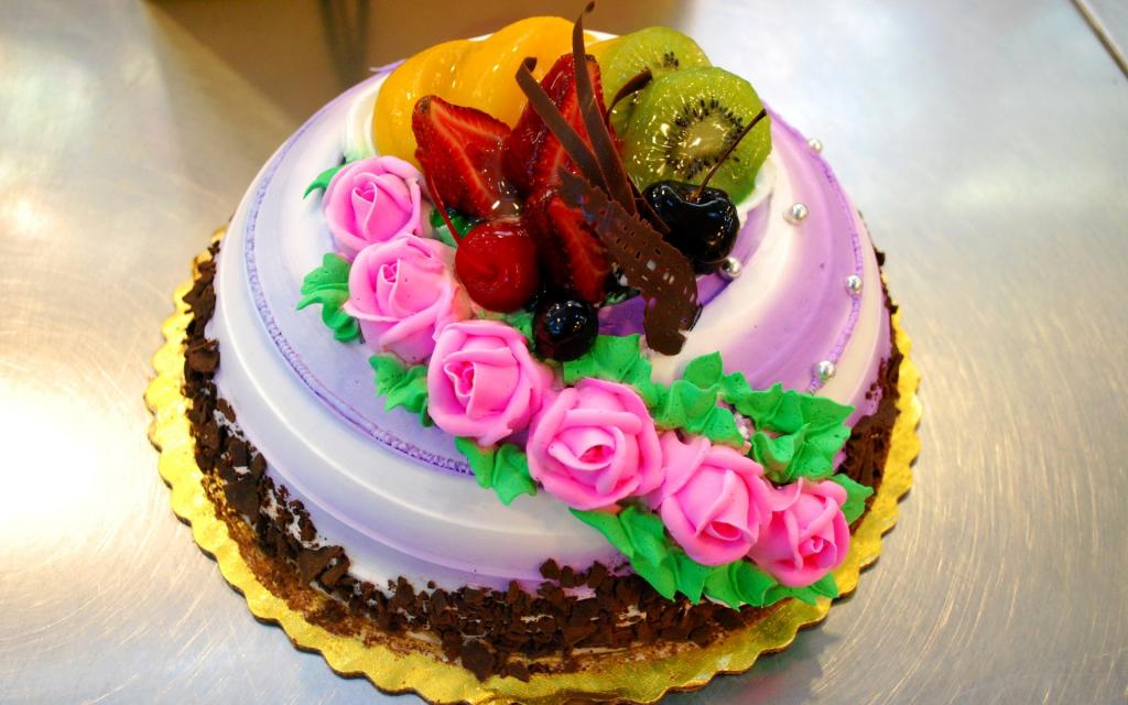 美丽的水果蛋糕装饰着粉红玫瑰从奶油