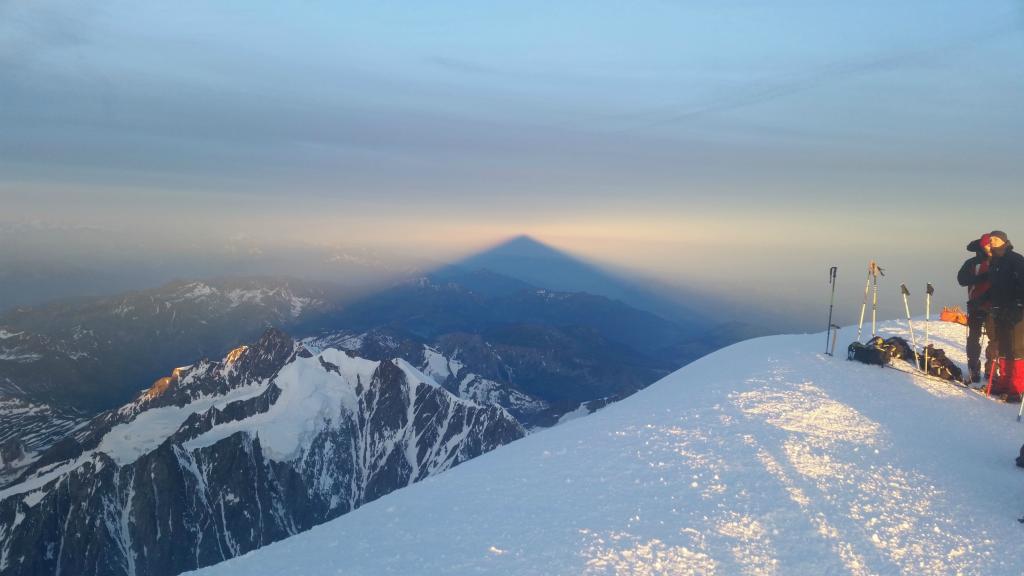 在山顶上的滑雪者在日落之前