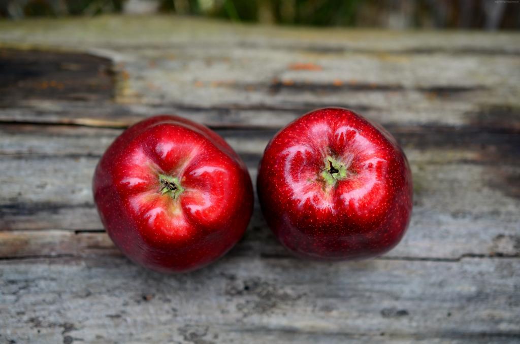 在一张木桌上的两个大红苹果