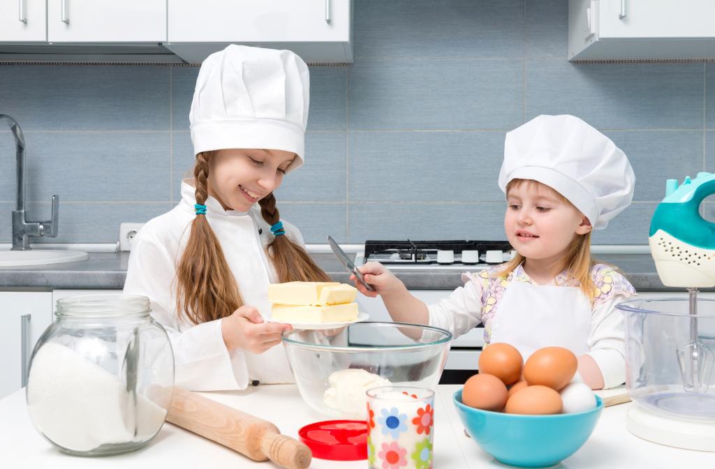 厨房里的两个小女孩准备一个蛋糕