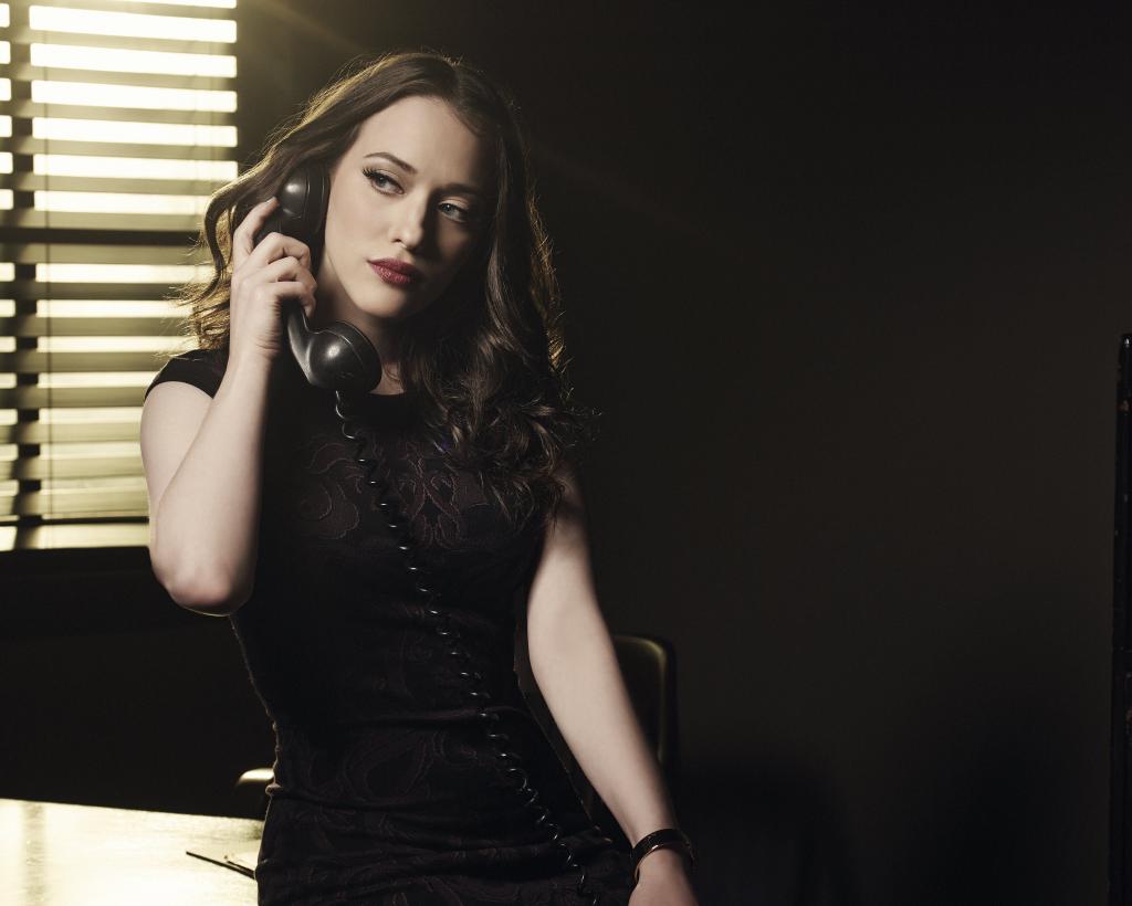 女演员猫丹宁在一件黑色的连衣裙，在她手中的电话