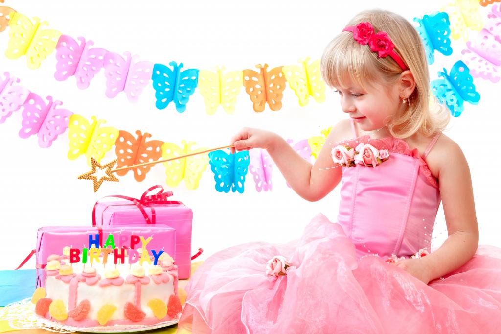 粉红色连衣裙的小女孩与蛋糕和生日礼物