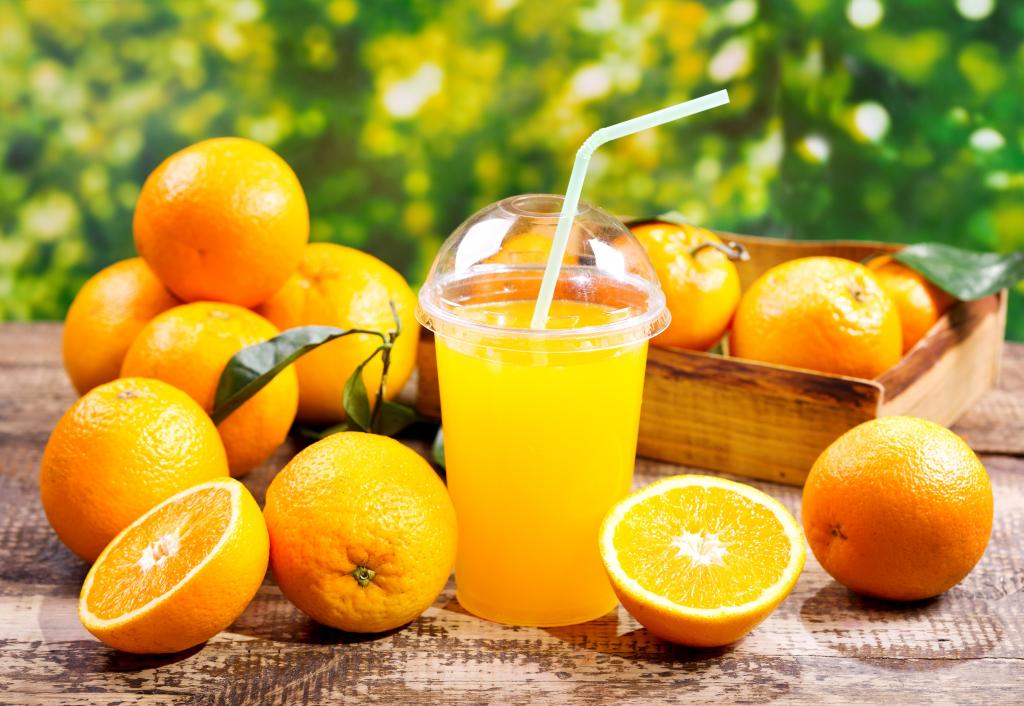 一杯橙汁，用新鲜的橘子桌上的稻草