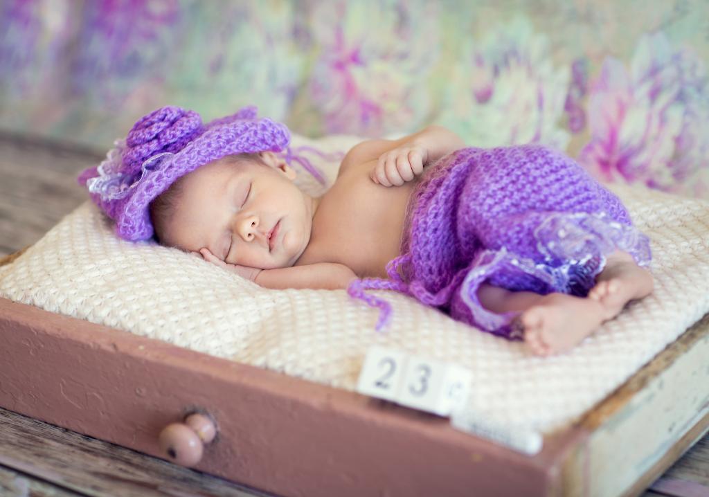 一个穿着针织紫色西装的小宝贝